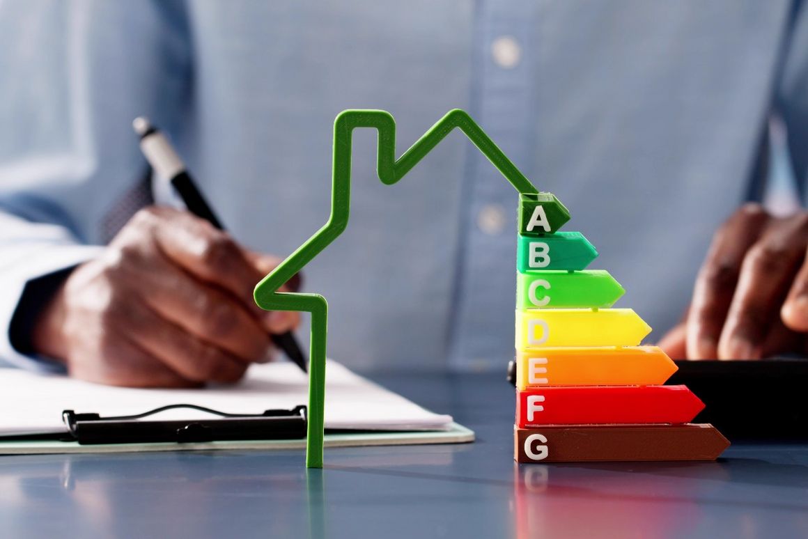 Hände mit Stift und Taschenrechner und Energieausweis